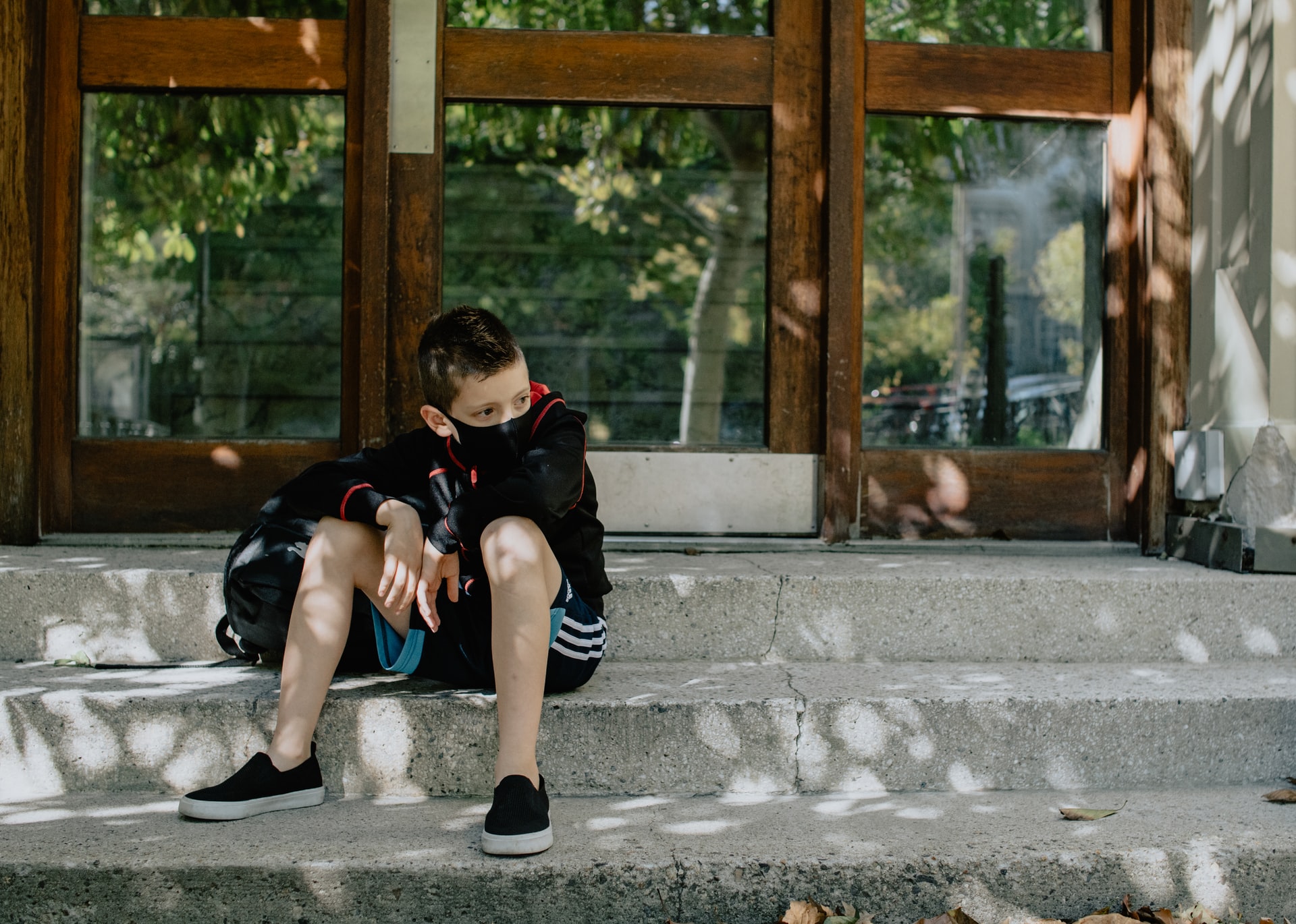 boy sitting on steps during covid-19