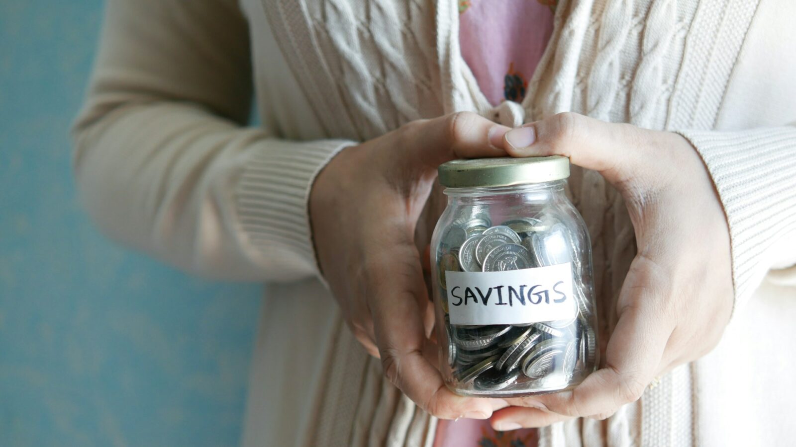 woman holding jar of saving money representing structured settlement funds being treated as income