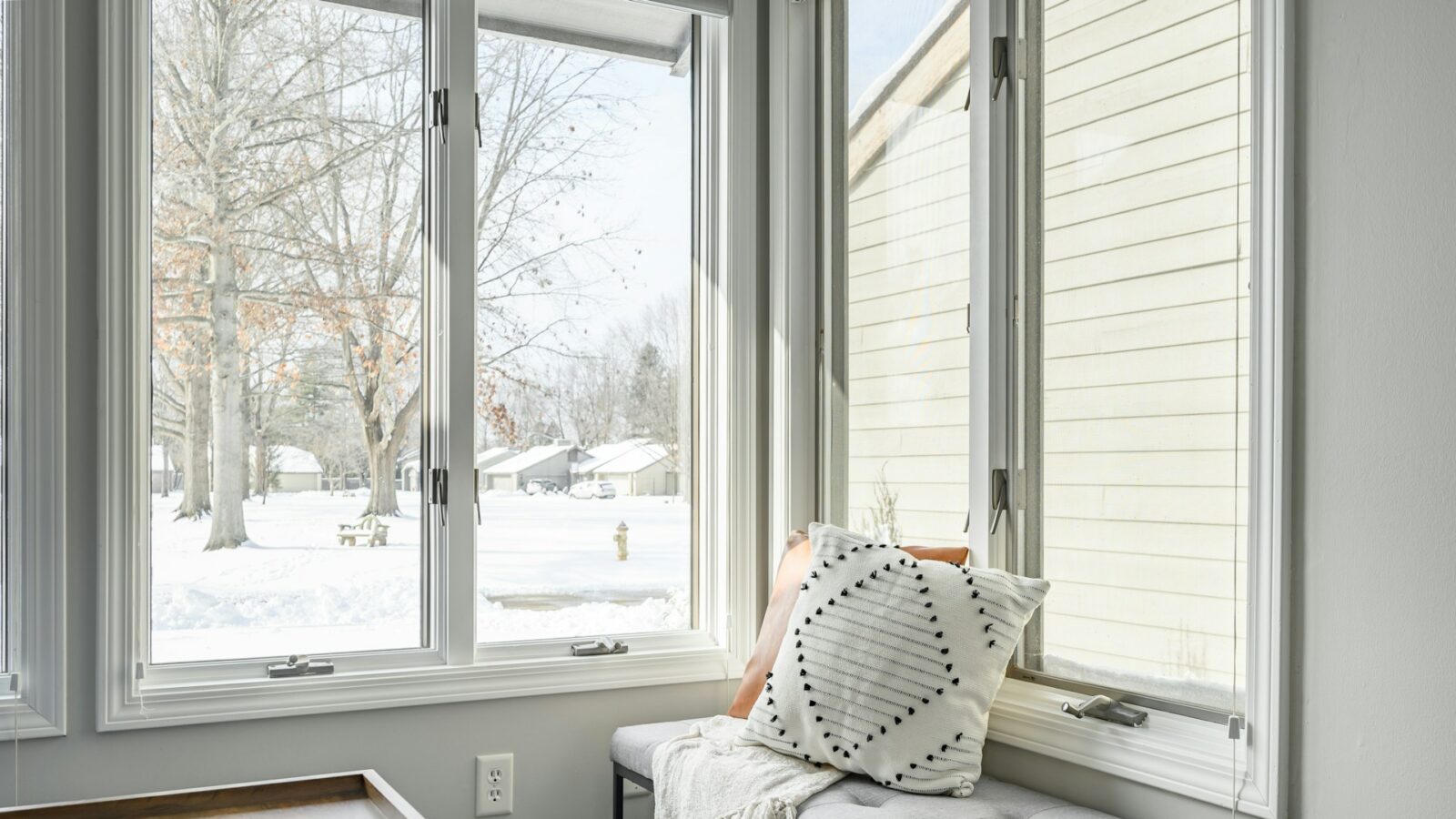 A cozy window reading nook looking out onto a snowy yard, representing the division of the family or matrimonial home after separation or divorce in Ontario
