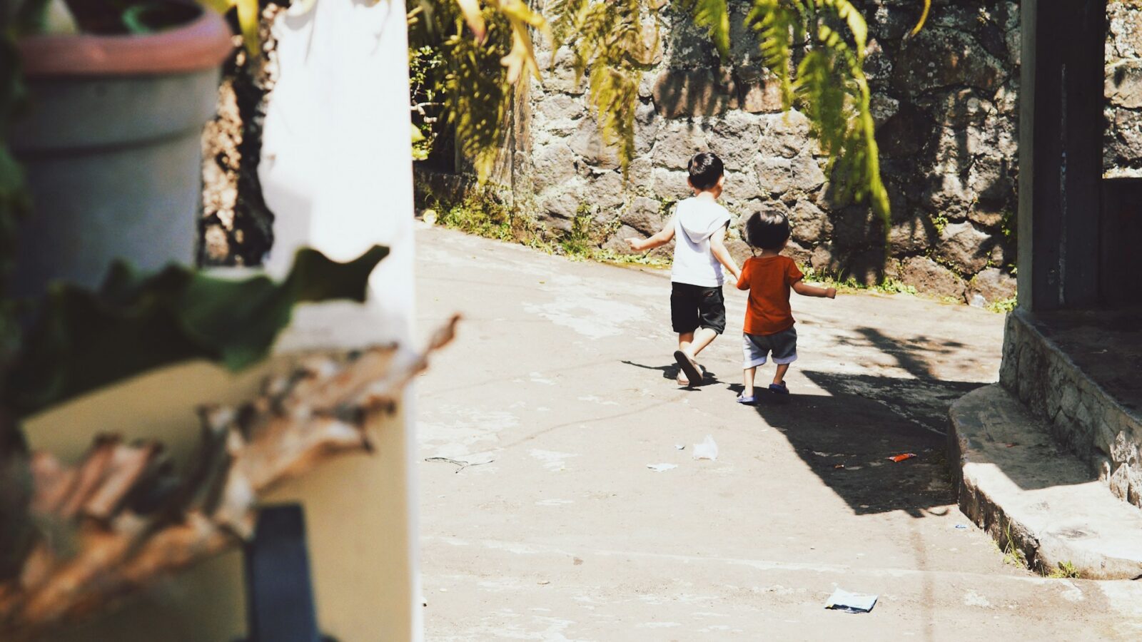 Two young children running outside representing international child retention in Ontario.