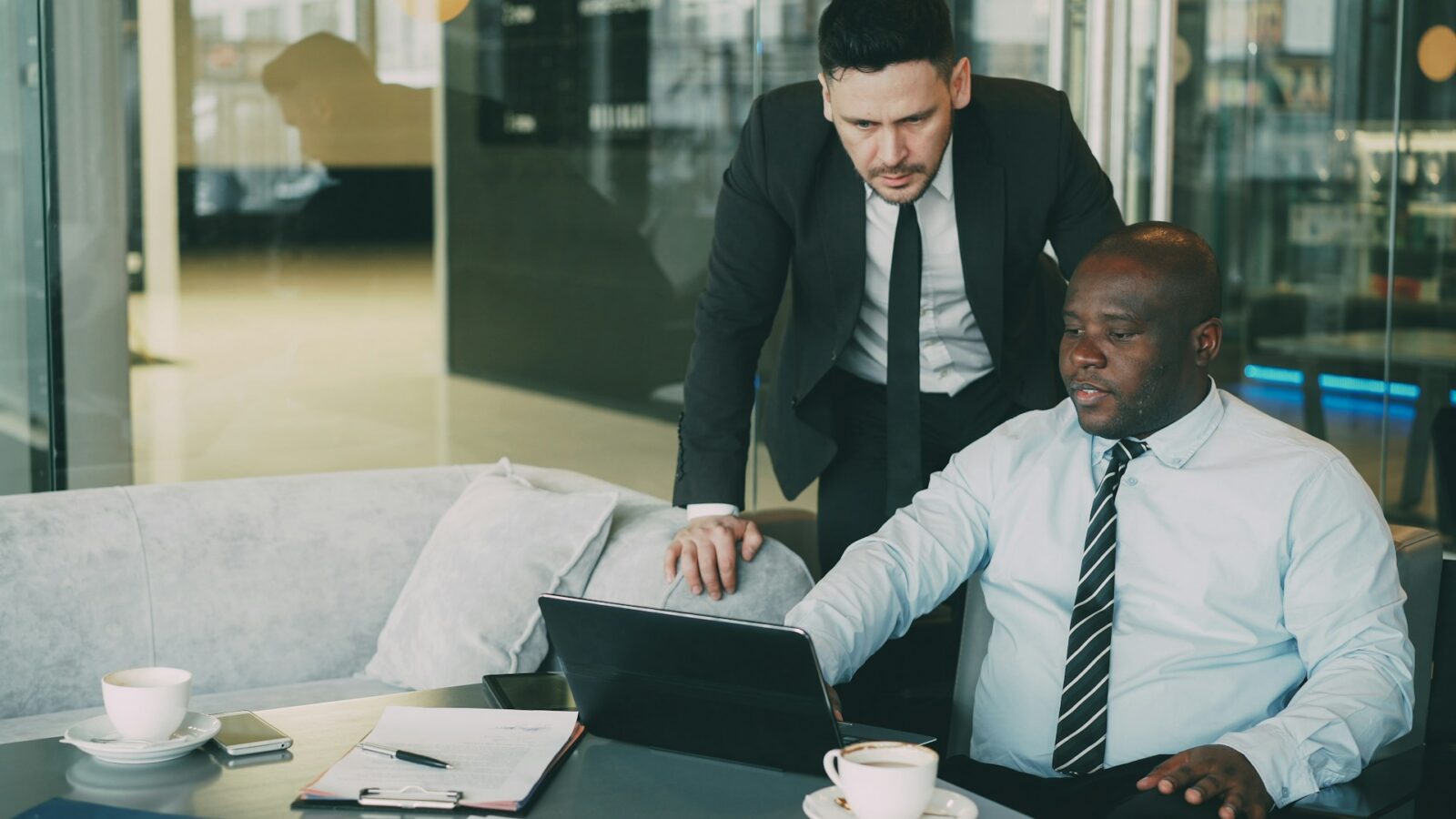 Two men looking at a laptop together, reviewing financial due diligence, representing the importance of independent legal advice when signing separation agreements in Ontario.